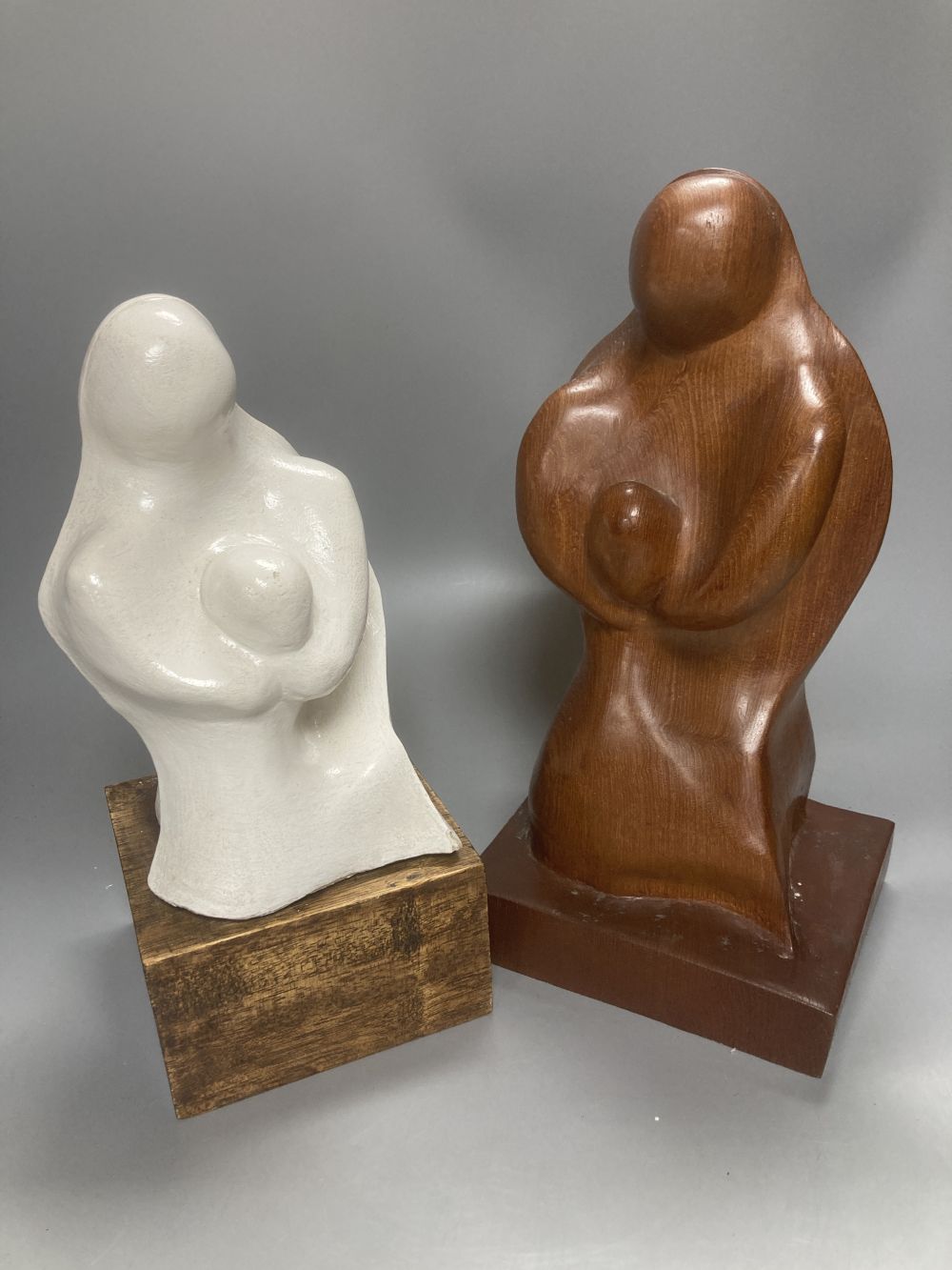 After Henry Moore, two related figural sculptures in wood and plaster, 31cm, white composition, 28cm